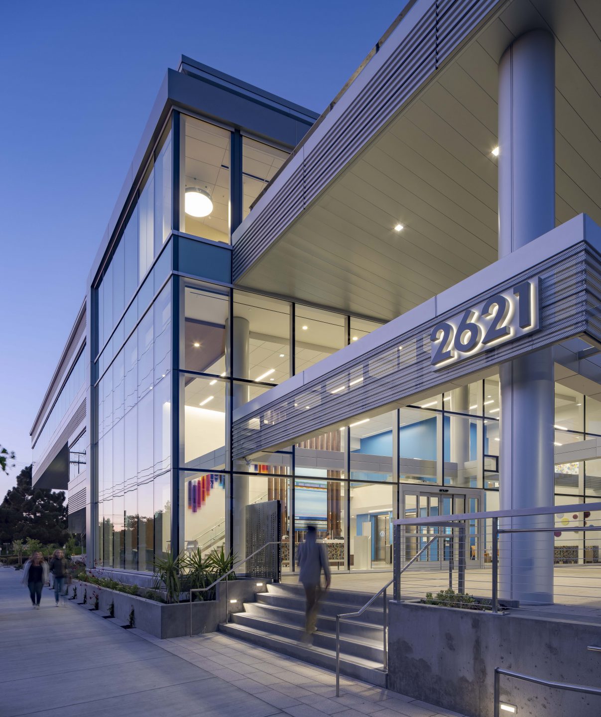 An exterior view of the Kaiser Permanente Berkeley Medical Office Building's double-height lobby at dusk.