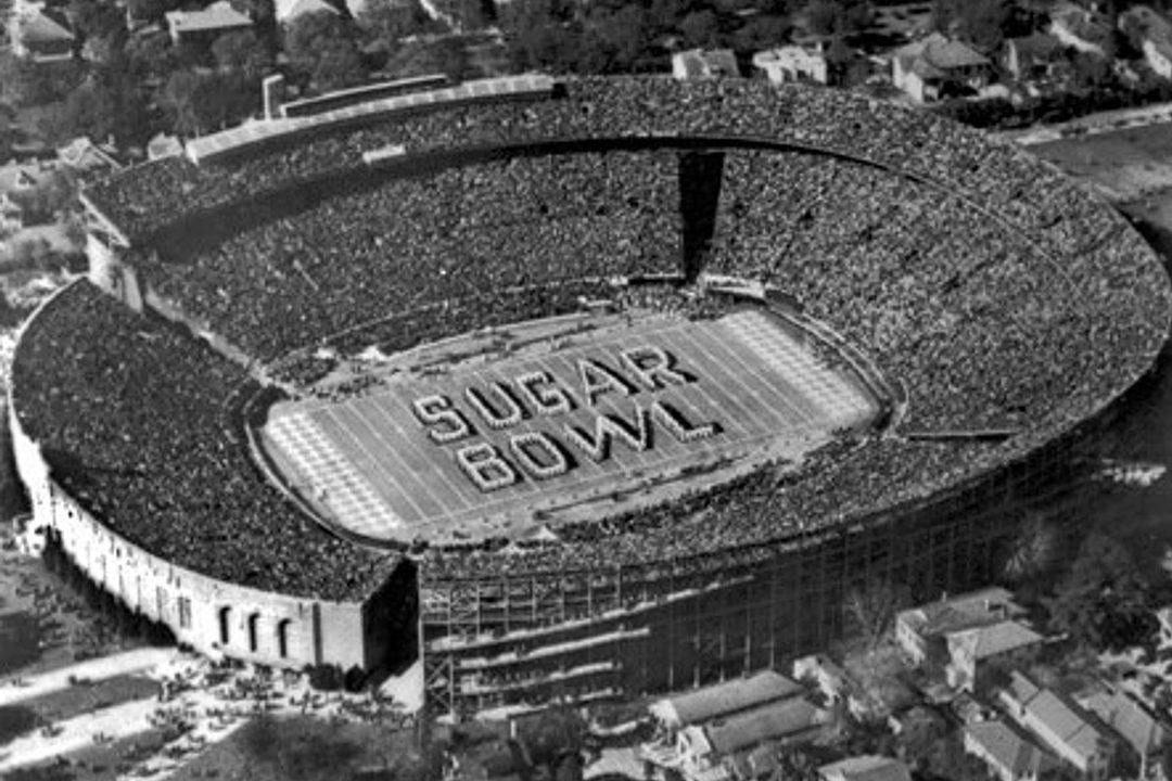 An aerial grayscale image of the former stadium at Tulane University during a Sugar Bowl game with "Sugar Bowl" written on the field