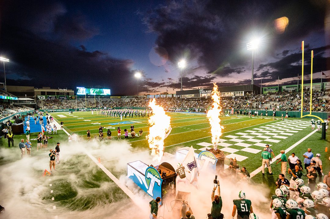 Image of a Benson Field pregame at night with Green Wave fans and celebratory flamethrowers