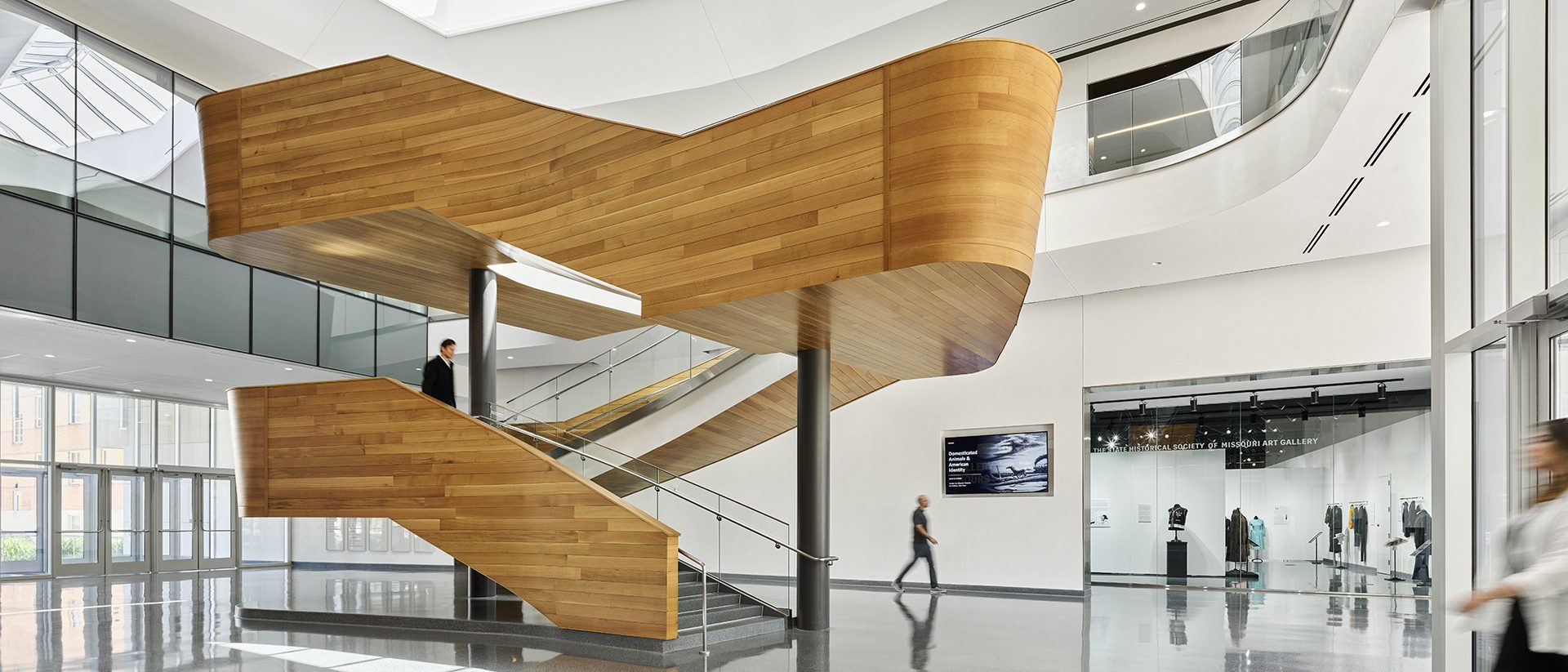 Image of the interior lobby of the SHSMO Center for Missouri Studies featuring a central wooden-clad sculptural staircase.