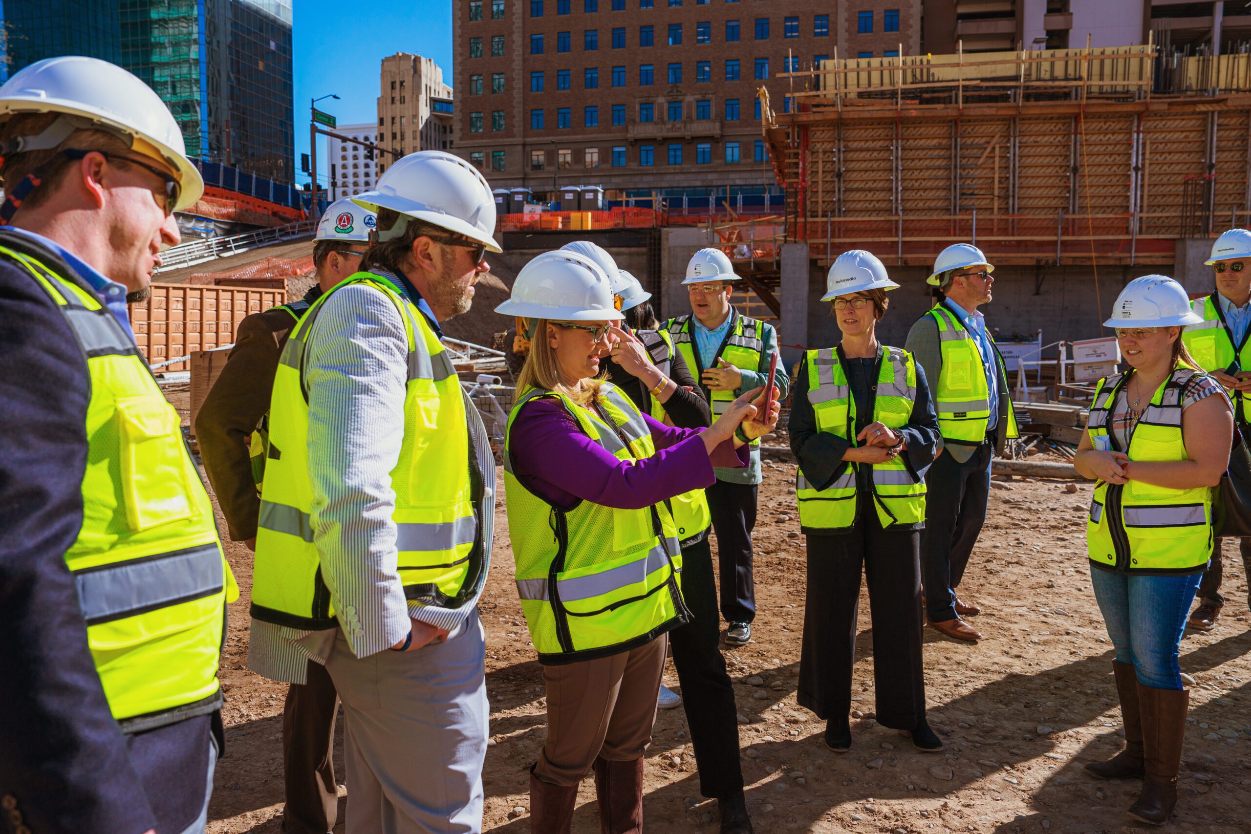 Image of team in neon construction vests meeting on site.