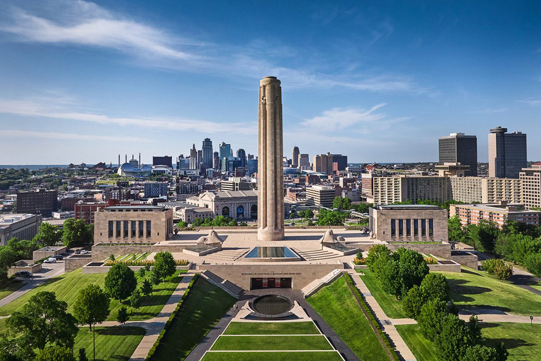 Aerial photo of the exterior of the National WWI Museum and Memorial grounds with Kansas City viewable in the background.