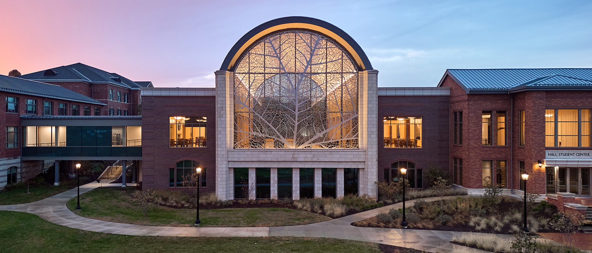 Dusk photo of Hall Student Center, Patterson Hall, a skywalk, and Centennial Hall which enclose the fourth side of the campus quadrangle.