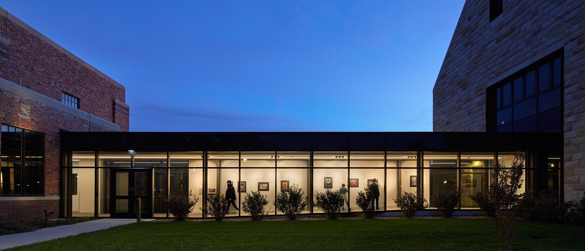 Exterior photo at dusk of the enclosed glazed walkway that connects the Schmidt Foundation Center for Art & Design to the Moss-Thorns Gallery.